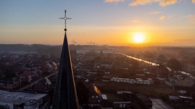 Sint Jozef, Rijkevorsel, Belçika 'daki katolik kilise kulesinin muhteşem turuncu mavi gökyüzü arka planında şehir manzarası silueti. Şehir manzaraları ve din kavramları.