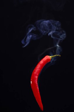 Siyah arka planda kırmızı kırmızı kırmızı biberler. Dumanı tüten sıcak kırmızı biberler.