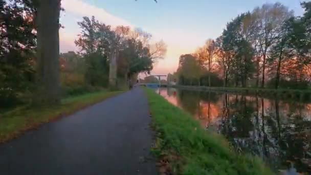 Pov hyperlapse of timelapse over een rivier met de rijzende zon en een idyllisch landschap en een draw brug — Stockvideo