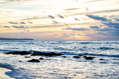 Denizde gün batımı, kayalar ve güneş. Cap Blanc-Nez, Fransa.