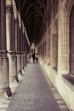 MECHELEN, Malines, Antwerp, BELGIUM, 2 Mart 2022, insanlar Mekke Belediyesi 'nin yan tarafındaki Gotik soportaldan veya kemerden geçiyorlar.