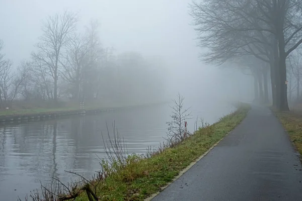 Бельгійський сільський канал з туманом і відображенням на світанку взимку. — стокове фото