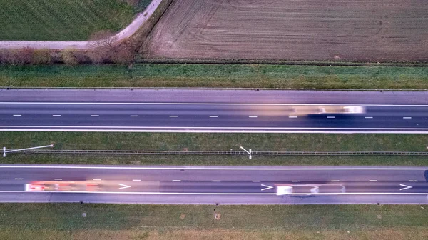 Sonnenaufgang von Wiesen und elektrischen Windrädern über Hochgeschwindigkeits-Autobahn am Morgen unter einem bunten Himmel Naturlandschaft über der Panoramalandschaft — Stockfoto