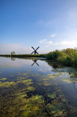 UNESCO 'nun dünya mirası sitesi Kinderdijk' teki ünlü Hollanda yel değirmenlerinden birinin dikey resmi. Fotoğraftaki 19 değirmenden biri Kinderdijk, Güney Hollanda, Hollanda 'daki