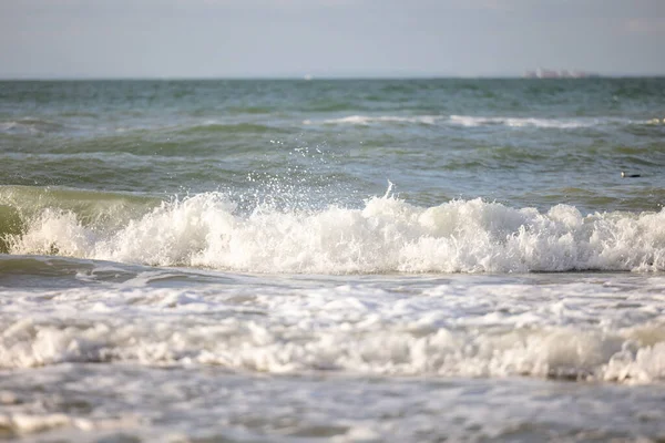 在蓝色落日的天空下，海浪在沙滩上一个接一个地拍打着拍打着，选用的焦点是. — 图库照片
