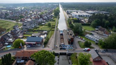 Rijkevorsel, Belçika, 25 Mayıs 2022, hava aracı kargo teknesini kanal kilidinde görüyor, yukarıdan bir kanalın manzarası, Avrupa 'da Schoten Dessel kanalı üzerinde mavna botuyla yolculuk. Yüksek