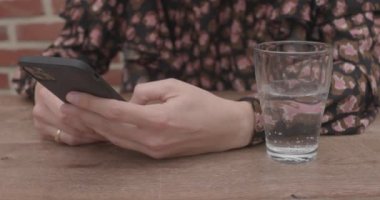 Bir kafede molada cep telefonundan video izleyen hippi kız, cep telefonunda cep telefonuna mesaj veya tanıtım içeriği için cep telefonunun boş fotokopi sahnesini çeker. Yüksek kalite