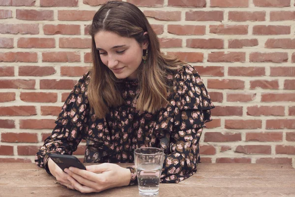 Çekici gülüşü olan beyaz kadın çiçekli bluz içinde akıllı telefon kullanıyor, portre genç seksi kız yatak odasında rahatlıyor. Teknoloji insanları dijital çevrimiçi pazar e-ticaret kavramını birbirine bağlıyor