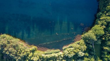 Yukarıdan mavi göller. Akşamları yeşil ormandaki göller, güneş ışığı hava aracı görüntüsü. Yazın sahne arkası. Ormanlı resimli göl kenarı. Yüksek kalite fotoğraf