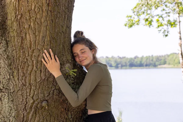 Joven Contenta Abrazando Gran Árbol Con Una Expresión Dichosa Sus — Foto de Stock