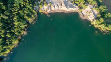 Blue lakes from above. Lakes in green forest in evening sunlight aerial drone view. Scenic summer background. Picturesque lakeside with forest. High quality photo. High quality photo