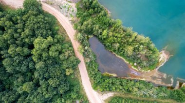 Blue lakes from above. Lakes in green forest in evening sunlight aerial drone view. Scenic summer background. Picturesque lakeside with forest. High quality photo. High quality photo
