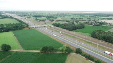 Brecht, Belgium, 6th of July, 2022, Panoramic aerial drone view of wind farm or wind park, with high wind turbines for generation electricity with the motorway with few cars and railroad next to it