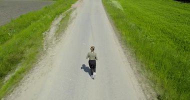 Sport woman running outdoor. woman jogging in rural area between the fields, aerial view. Back view of running people active training in park. fitness runner jogging outdoor. Sport people running in