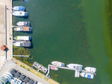 Aerial view of amazing boats. Minimalistic landscape with boats in a bay. Top view from drone of harbor or port with yachts, motorboat and sailboat. High quality photo