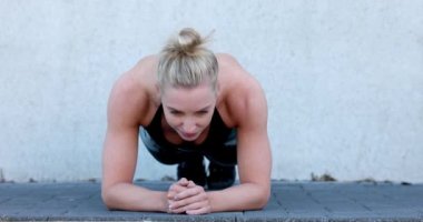 Çekici, sportif bir kadın spor yaparken spor salonuna konsantre oluyor. Genç mükemmel şekilli sarışın kalas yapıyor. Yüksek kalite 4k görüntü