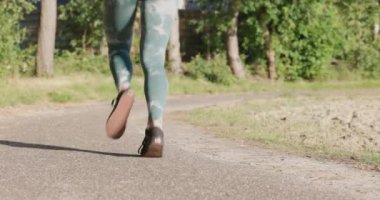 Close up of female legs running on field road outdoors at dawn in summer, concept of healthy running and outdoor exercise. High quality 4k footage