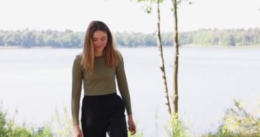 Young pretty woman walking in a forest lake towards the camera. High quality 4k footage