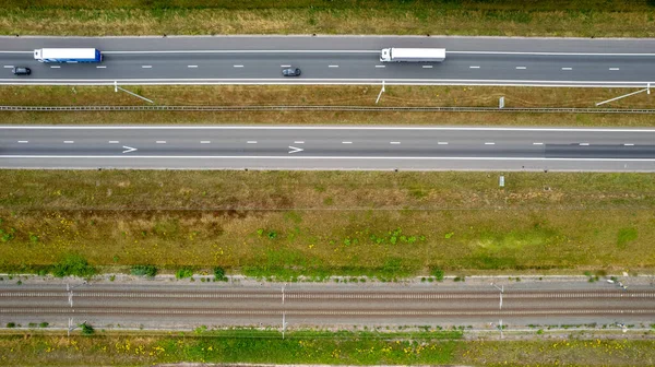 Aerial view of highway road junction. Highways, railroads, and green fields on the outskirts of the city. in Belgium Transport concept. High quality photo shot by a drone
