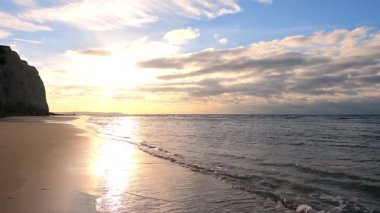 Okyanus dalgaları üzerinde günbatımının yavaş çekimi kum plajlarını yıkar. Dağ siluetinin üzerinde hava güneşi batıyor. Tropik hiç kimse doğa deniz manzarası. Yüksek kalite 4K çekim slomosu