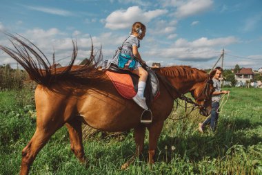 Sahada atı olan genç bir kadın.