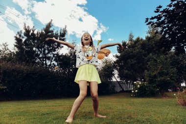 Gökyüzü ve ağaçların arka planına karşı kollarını açmış bir çocuk. Parkta yaz kıyafetleri içinde mutlu bir kız. Doğada geçirilen zaman. Parkın dışında bir çocuğun portresi. Odaklan, odaklan..