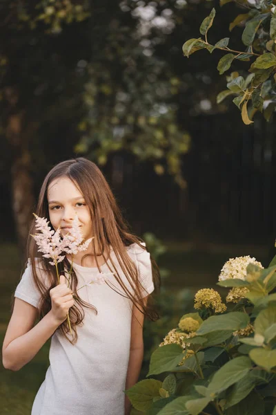 Egy Mosolygó Kislány Arcképe Aki Puha Rózsaszín Virágokat Tart Kezében — Stock Fotó