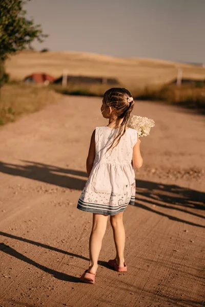 Красивая Маленькая Девочка Светлом Летнем Белом Платье Позирует Солнце Букетом — стоковое фото