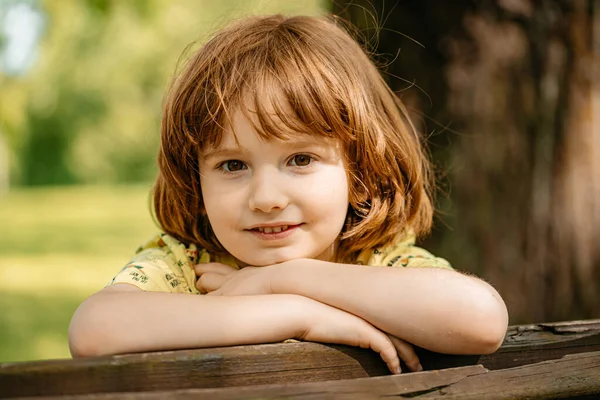 Uma Criança Senta Banco Parque Dia Ensolarado Verão Retrato Menino — Fotografia de Stock
