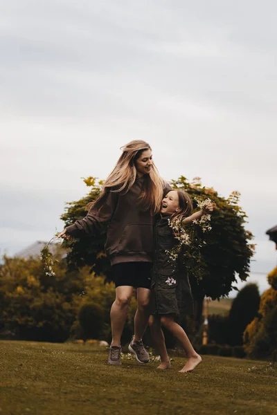 Две Красивые Молодые Девушки Длинными Волосами Позирующие Природе Держащие Цветы — стоковое фото