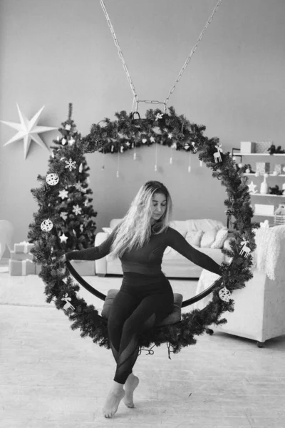 クリスマスツリーの黒いドレスの美しい若い女性 — ストック写真