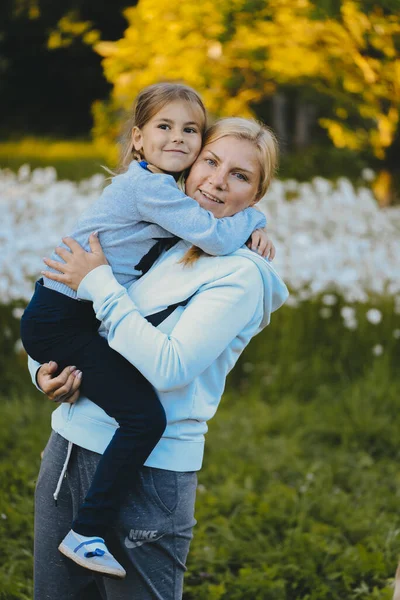 自然を背景にした少女と母親の肖像画 ママは娘を抱っこしてる 愛とケアの概念 彼女の娘と一緒に公園を散歩 — ストック写真