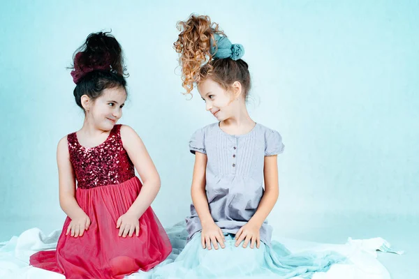 Две Маленькие Улыбающиеся Девочки Платьях Сидят Полу Смотрят Друг Друга — стоковое фото