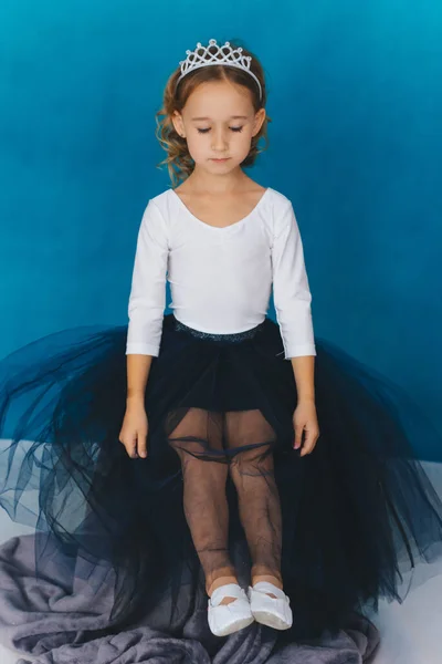 Uma Menina Vestido Magnífico Senta Fundo Uma Parede Azul Uma — Fotografia de Stock