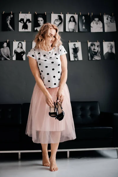 Sweet Girl Blond Wavy Hair Pink Skirt Standing Black Sofa — Φωτογραφία Αρχείου