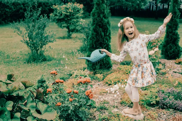 Una Graziosa Bambina Con Una Corona Fiori Testa Annaffiatoio Sorseggia — Foto Stock