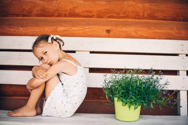 Uma Menina Com Tranças Vestido Branco Verão Ofendida Senta Banco — Fotografia de Stock