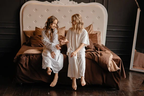 Két Gyönyörű Kislány Hosszú Fehér Sarochki Egy Nagy Ágyon Gyerekek — Stock Fotó