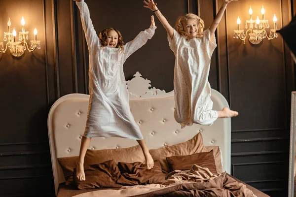 Két Boldog Kislány Hosszú Fehér Sarochki Ban Ugrál Ágyon Energetikus — Stock Fotó