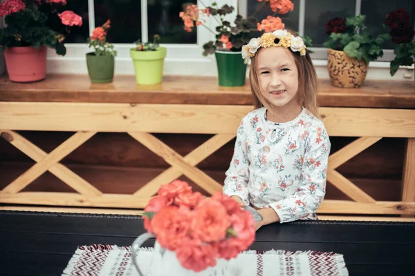 Uma Menina Senta Uma Mesa Entre Flores Frescas Retrato Uma — Fotografia de Stock