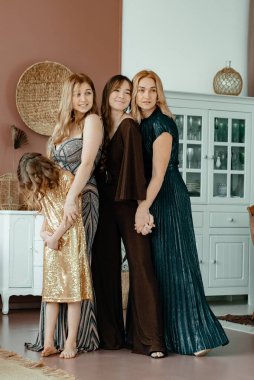 Genç, çekici bir anne ve uzun, güzel elbiseli üç kızı odada. Aile nesli. Farklı yaşlarda, gece elbiseleriyle şık kızlar..