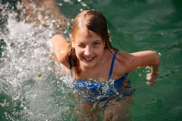 Ένα Όμορφο Κοριτσάκι Μακριά Σκούρα Μαλλιά Ένα Μπλε Μαγιό Κολυμπά — Φωτογραφία Αρχείου