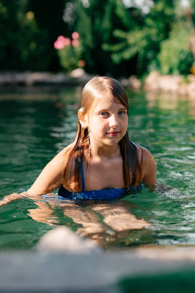 Ένα Όμορφο Κοριτσάκι Μακριά Σκούρα Μαλλιά Ένα Μπλε Μαγιό Κολυμπά — Φωτογραφία Αρχείου
