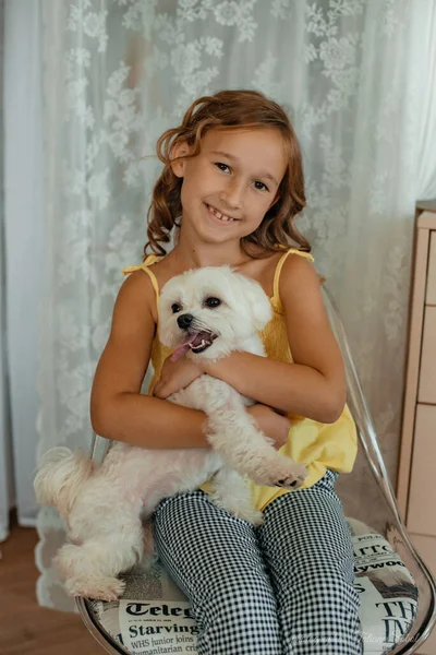 Ein Lächelndes Mädchen Mit Braunen Augen Und Lockigem Haar Sitzt Stockfoto