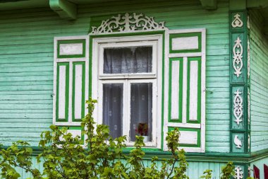 Yeşil çimen ve mavi panjurlu eski bir ev penceresi.