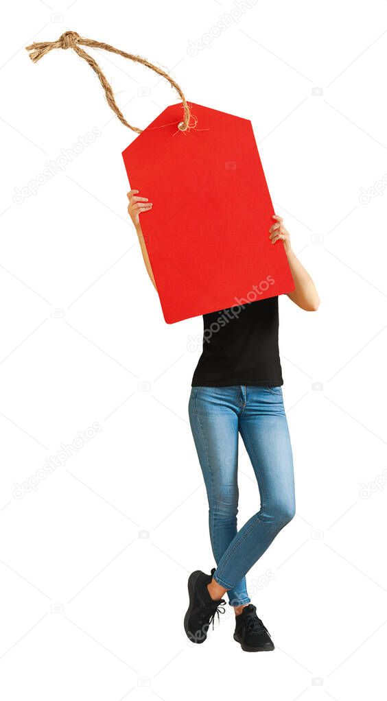 Standing woman holding a red sale tag in hands. Isolated on white background.