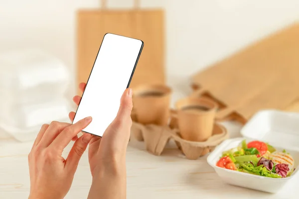 Kobieta trzyma smartfona i składa zamówienie online. Dostawa żywności — Zdjęcie stockowe