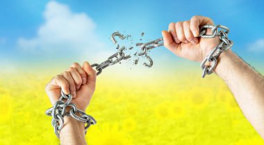  Mens hands break the chains on Ukraine flag colors background. Freedom concept clipart