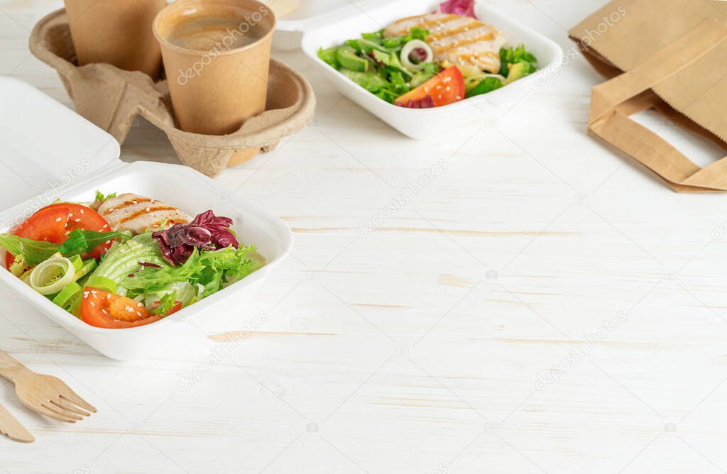 Food delivery of healthy lunch boxes and coffee on white wooden background. Copy space.