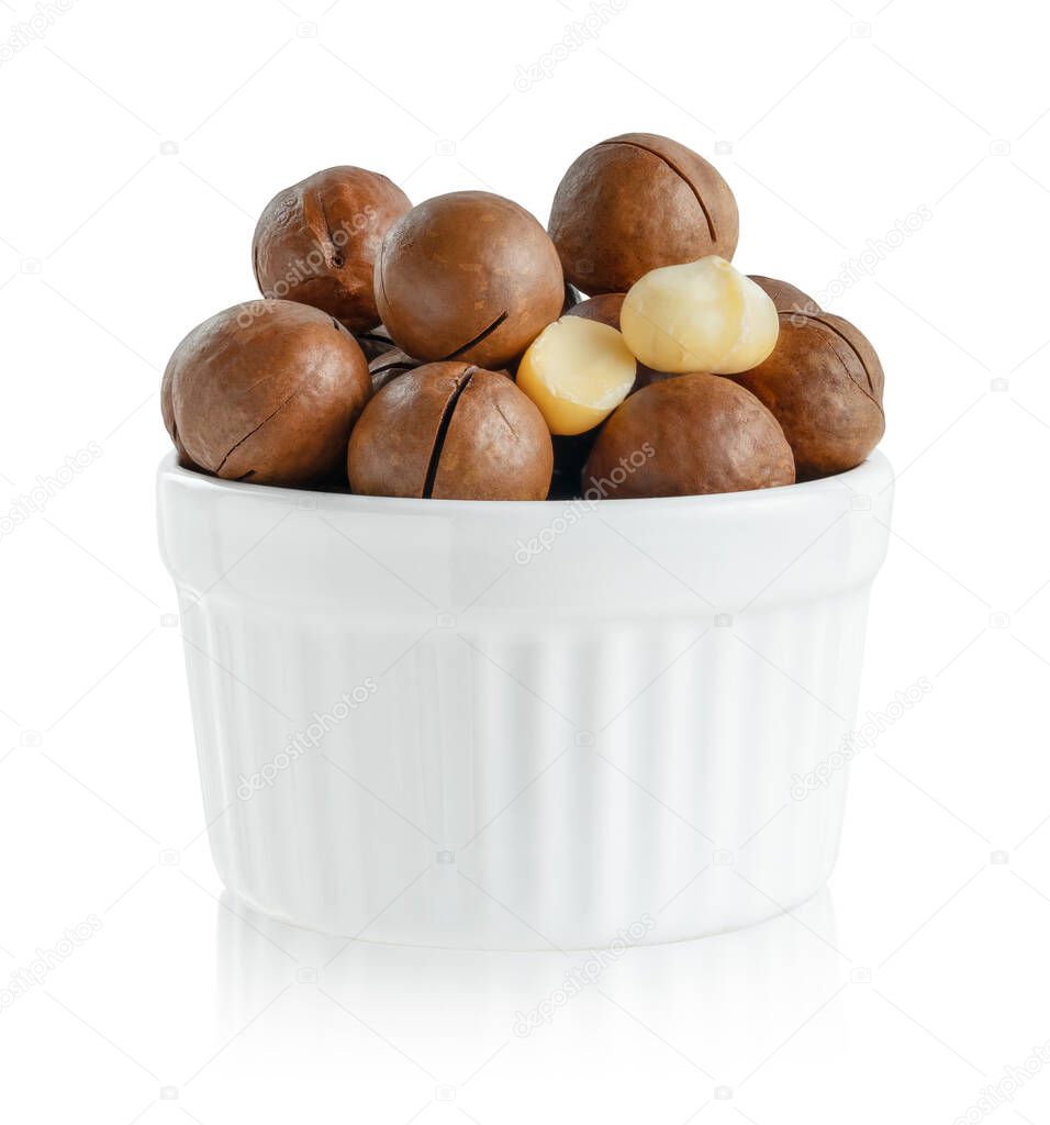 Macadamia nuts in a bowl on white background isolated with clipping path.